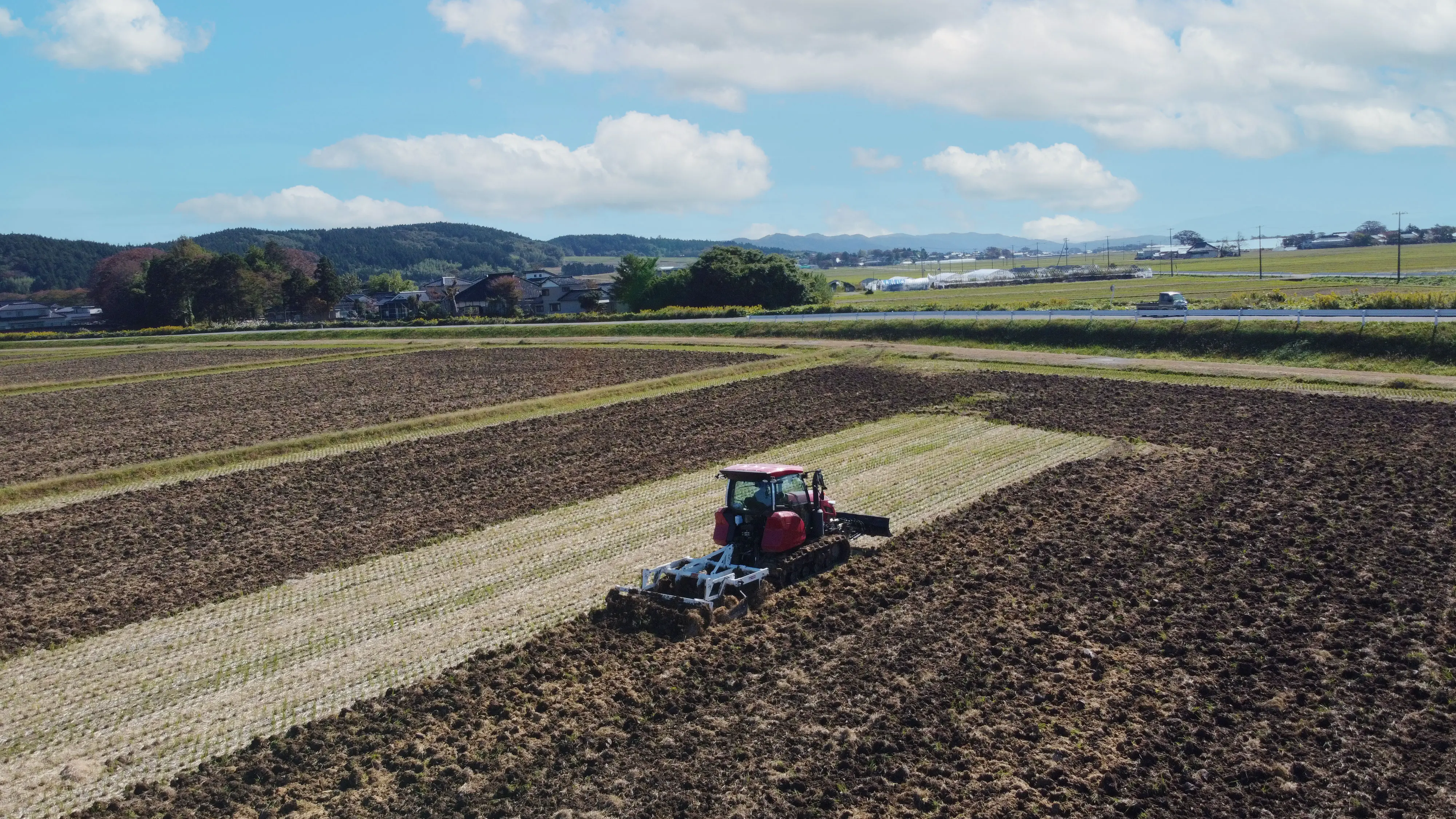 稲刈り後の田を耕している様子